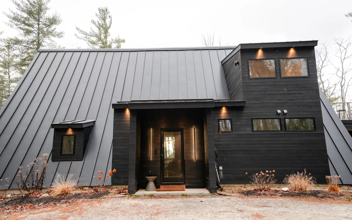 Modern dark house with a standing seam metal roof