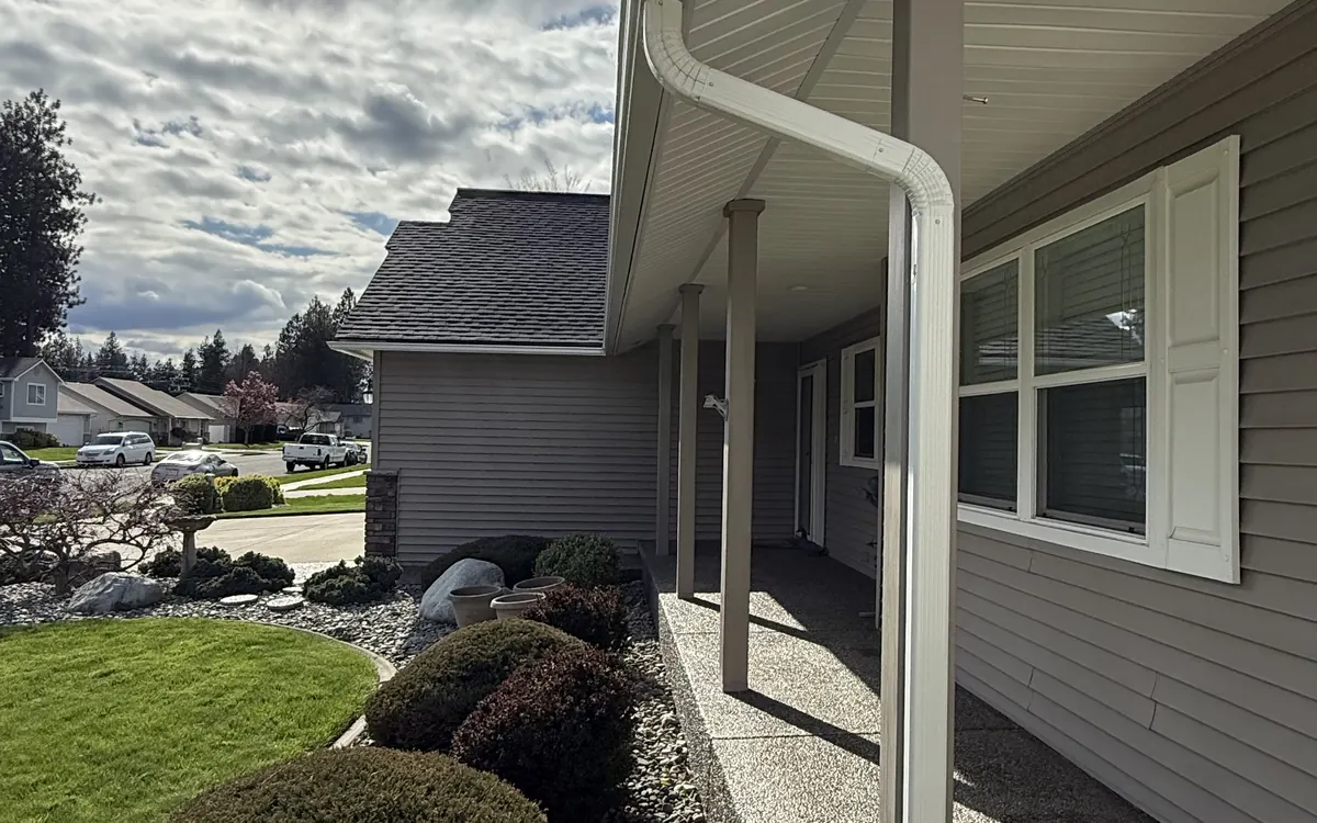 Gutter and downspout along the roofline of a home, photographed by Lakeview Roofing