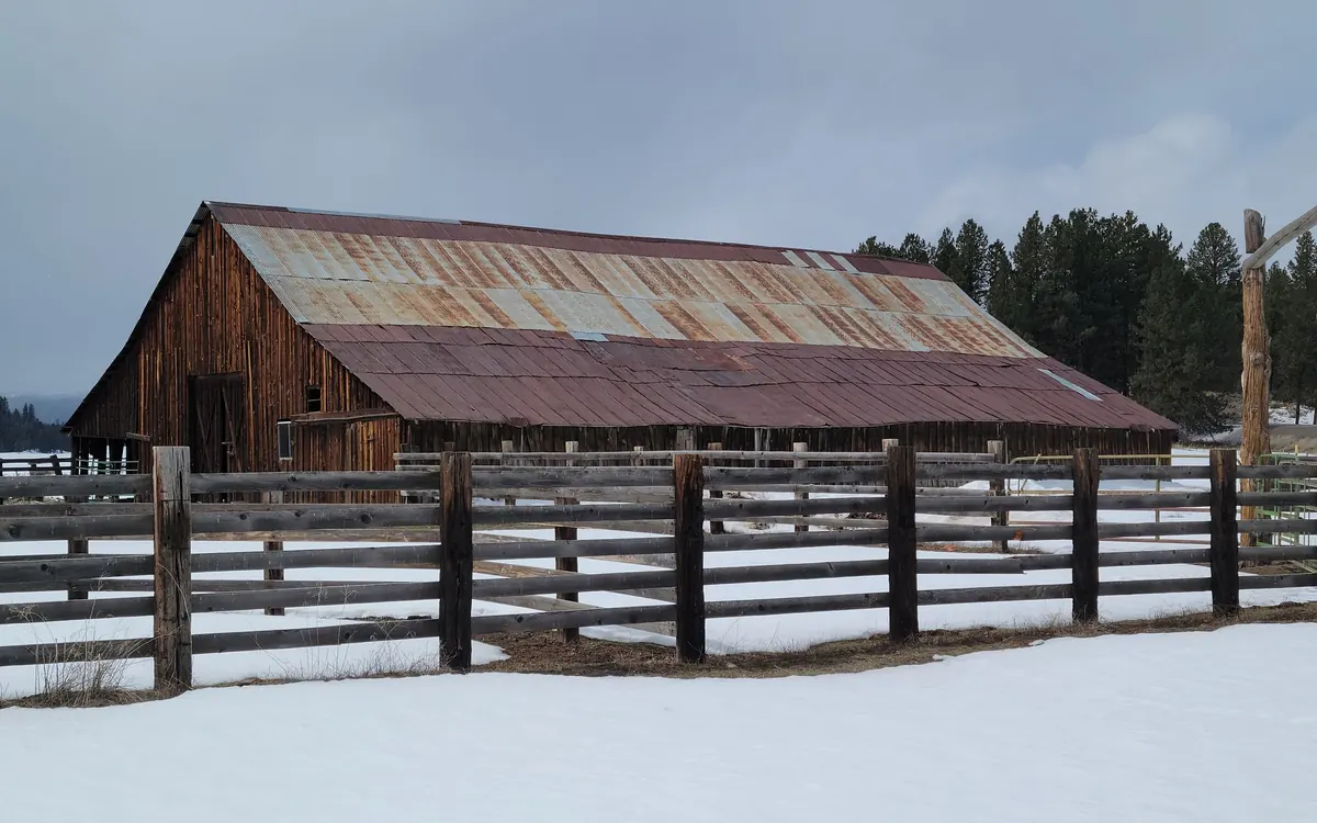 Barn with a metal roof in a snowy field