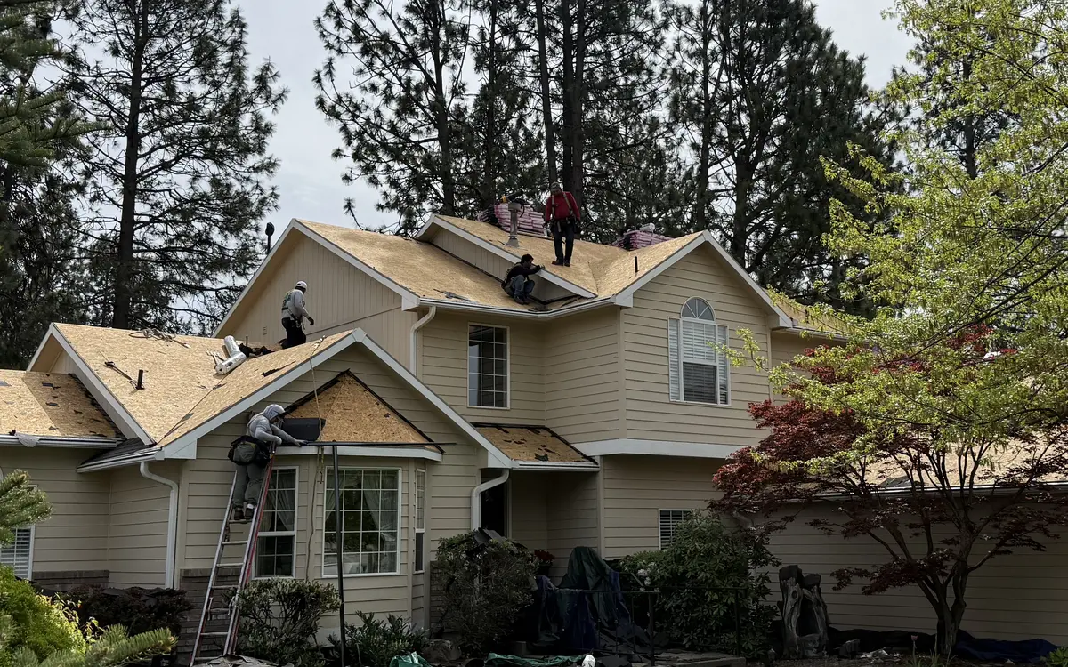 Roofing crew working on bare roof decking after a tear-off